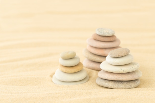 Sea pebbles stacked on top of each other in the sand  a summer backdrop for relaxation