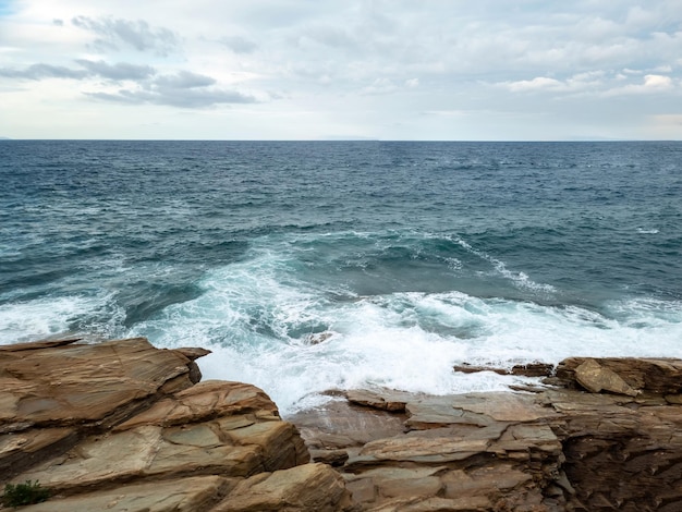 Sea ripple water white foam on wet rocky surface Greek island Cyclades Greece Space