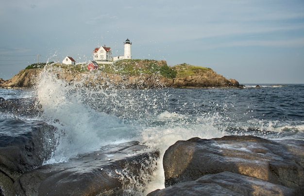 sea rock landscape with wave crushing Nubble Lighthouse historic lighthouse Cape Neddick Point York Maine USA