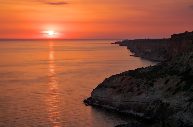 Sea and rock at the sunset. Nature composition