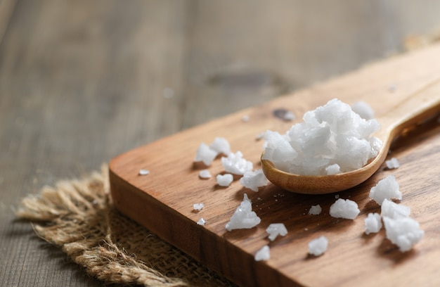 Sea salt in wood spoon on wood block 