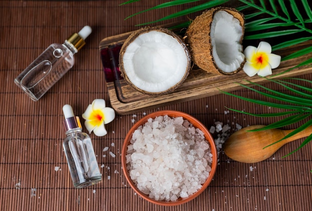 sea salt in a wooden spoon with coconut for beauty care and mango flowers