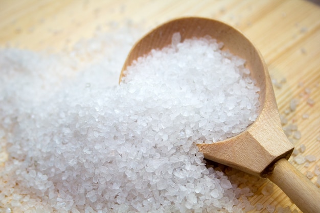 Sea salt in wooden spoon on wood