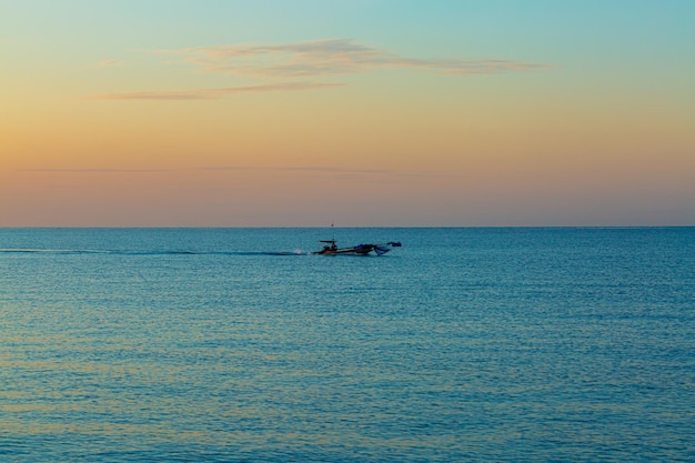 sea and small fishing boats in the morning,A small fishing boat in the middle of the sea at sunset