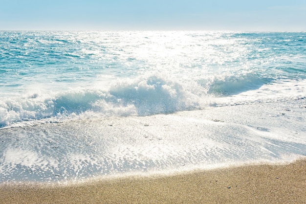 Sea surf on a sandy beach on a windy sunny day