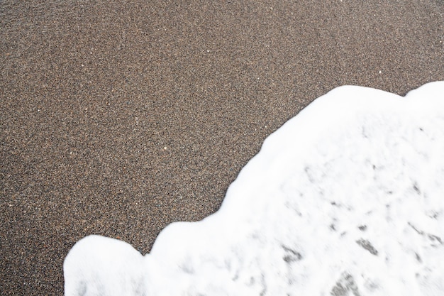 Sea surf on the seashore on the sand Sea foam on the sand