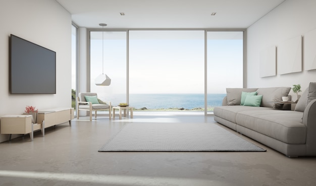 Sea view living room of luxury summer beach house with large glass door and wooden terrace.