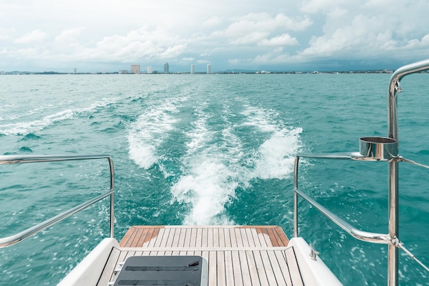 Sea wave from catamaran yacht engine with Pattaya beach and sky in the background Heading to travel destination to Koh Larn Chonburi province Thailand