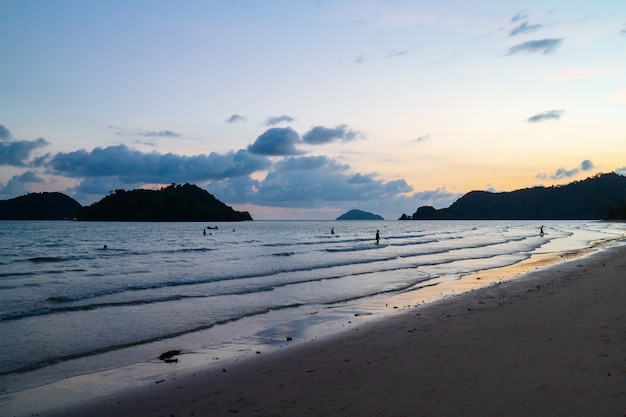 Sea wave moving to the beach with green islands and blue