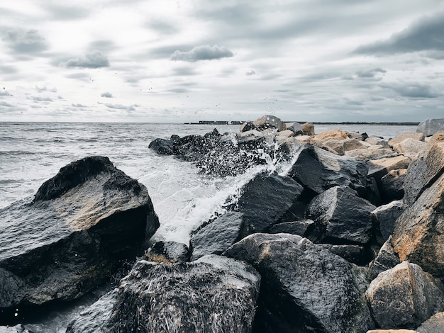 Photo sea waves breaking on rocks with water splashes