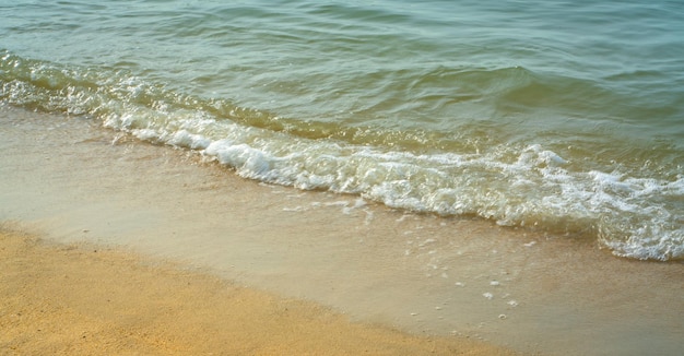 Sea waves making white foam crashing on the shore