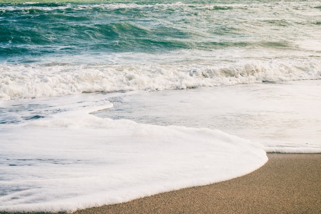 Sea waves and sand on the beach in retro colors