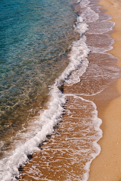 Sea waves on the surface of a sandy beach side view