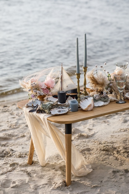 Sea wedding decor on the coast. Wedding cake and flowers at the event.