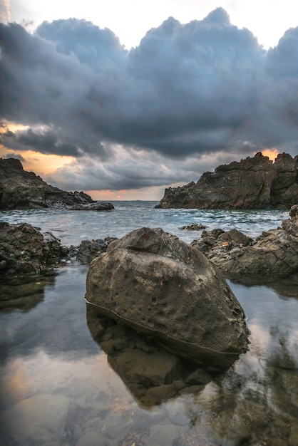 Sea with a sunset and the black cloudy 