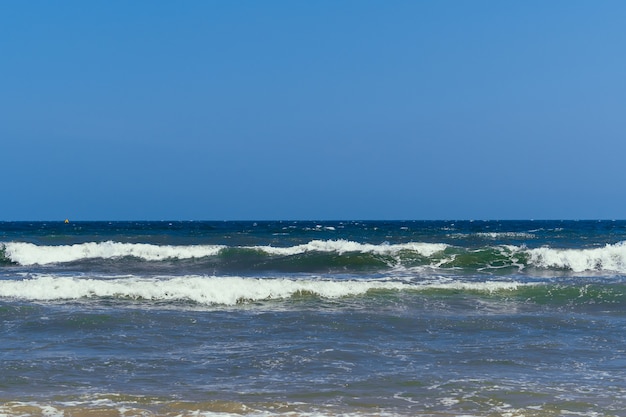 sea with waves on a cloudy day with kitesurfers