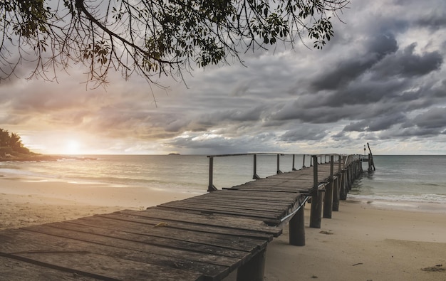 Sea wooden bridge and raining clouds with sunrise lighting.