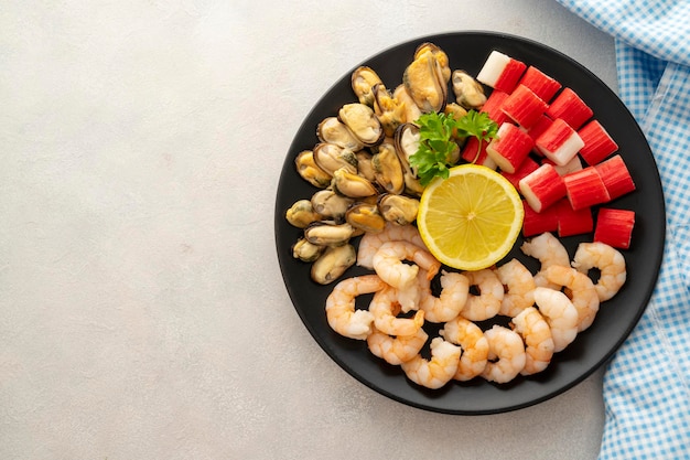 Seafood charcuterie shrimps mussels and crab sticks in plate bright background top view