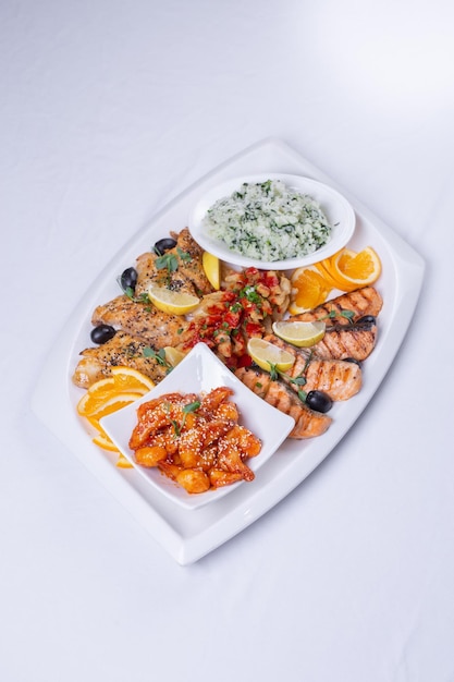 seafood mixture on a white grill Delicious grilled fish shrimp in sauce and salmon on the table top vie