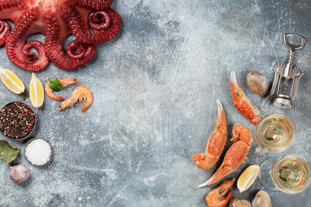 Photo seafood. octopus, lobster, clams cooking. top view with white wine on stone table with space for your text