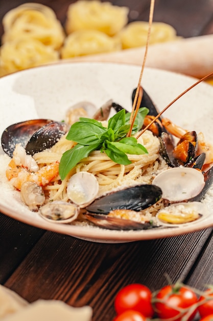 Seafood Pasta with mussels and basil in  plate on wooden table