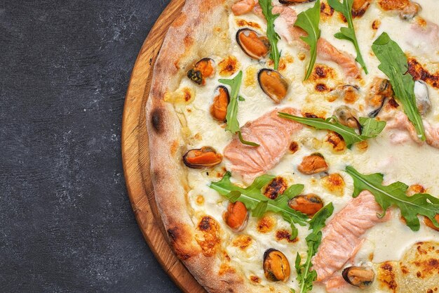 Seafood pizza marinara di mare with salmon mussels and arugula