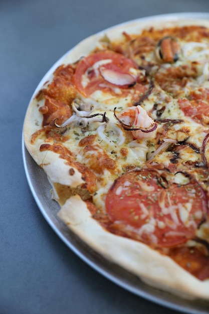 Seafood pizza , with mussel squid shrimp and tomato , italian food