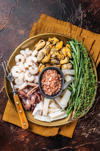 Seafood platter mix of mussels clams squid octopus shrimps and prawn Dark background Top view