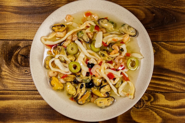 Seafood salad with shrimp, squid and mussels on wooden table. Top view