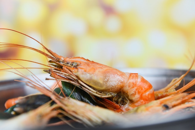 Seafood shellfish with steaming shrimps prawns mussel crab boiled in hot pot and bokeh 