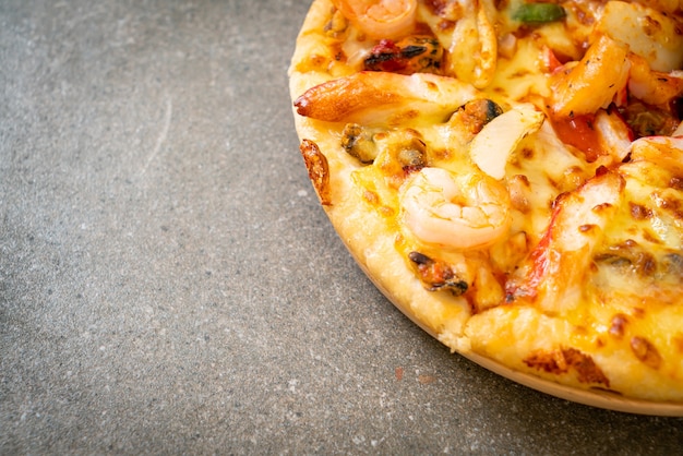 seafood (shrimps, octopus, mussel and crab) pizza on wood tray