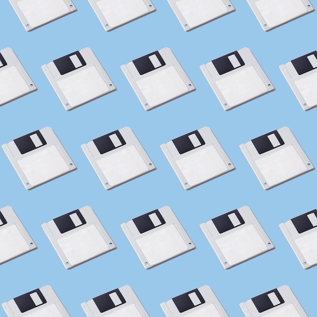 Seamless pattern of floppy disks for a computer on a blue background Retro gadgets