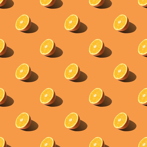 Seamless pattern of half sliced orange on orange background Minimal flat lay food texture