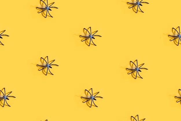 Seamless pattern with black spider on yellow