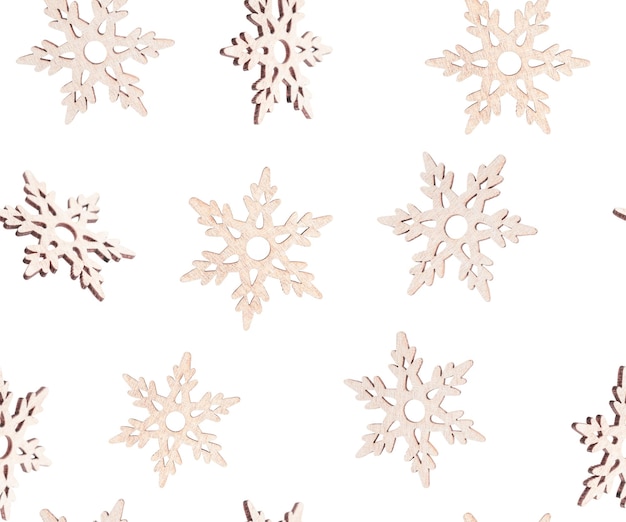 Seamless pattern of wooden carved snowflakes on white backdrop used as christmas or new year decor