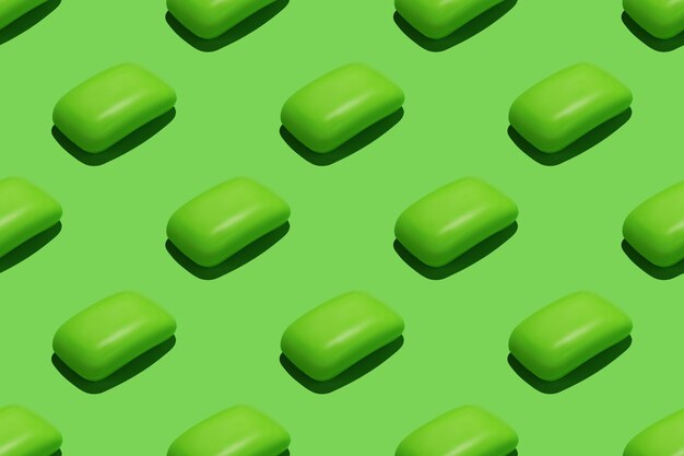 Seamless repetitive pattern with green soap bars on green background.