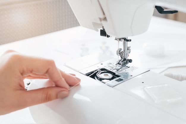 Seamstress adjusts the sewing machine to work