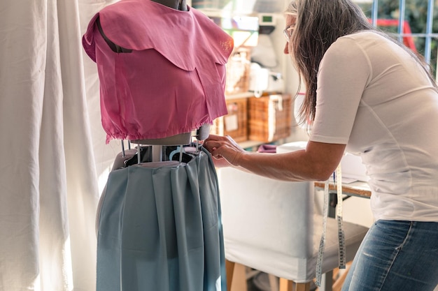 Seamstress fitting a skirt on a mannequin