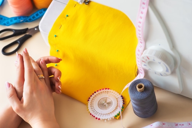 Seamstress's workplace. Professional sewing machine at work. Sewing machine sews bright textiles, meter and colored threads for sewing