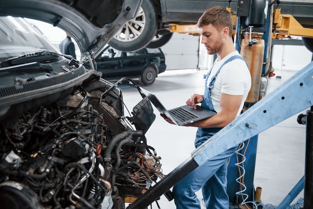 Searching for the items. Employee in the blue colored uniform works in the automobile salon