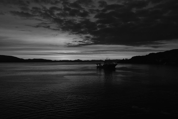 Seascape after sunset in Bergen Norway Ship in sea in evening dusk Dramatic sky over sunset sea water Traveling with adventures by ship sunrise Beauty of nature Wanderlust and vacation