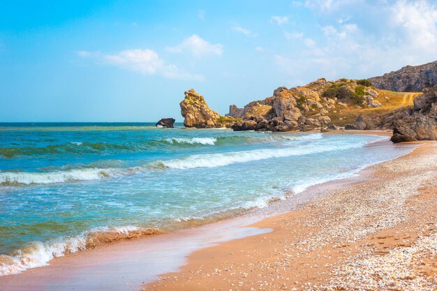 Seascape Blue sea and rocky shore with yellow sandy beach Sea of Azov in Crimea