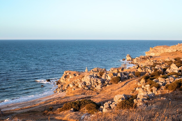 Seascape rocky crimean seashore with a field road in the evening travel and tourism