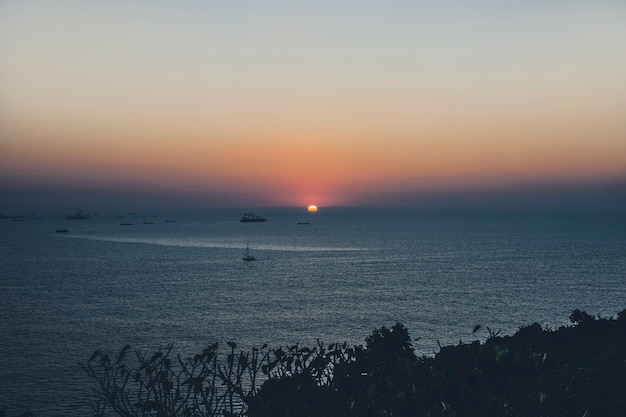 Seascape at sunset boats and ships at sea against the background of the setting sun