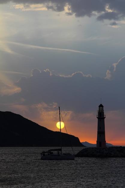 Photo seascape at sunshine lighthouse and sailings on the coast seaside town of turgutreis and spectacular sunshine