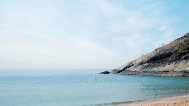 Seascape view of HuaHin beach with giant hill on blue sky background