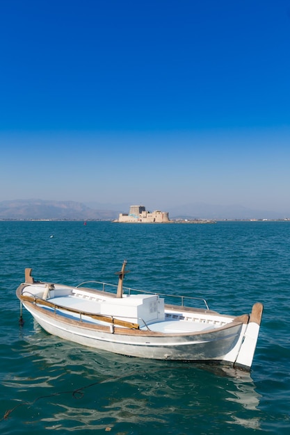 Seascape with fishing boat and Bourtzi castle in background Nafplio Greece