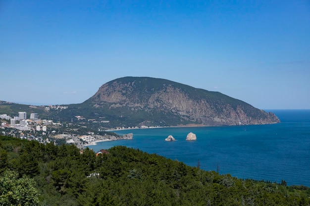 Seascape with a lonely mountain and houses at the foot of the mountains Black Sea