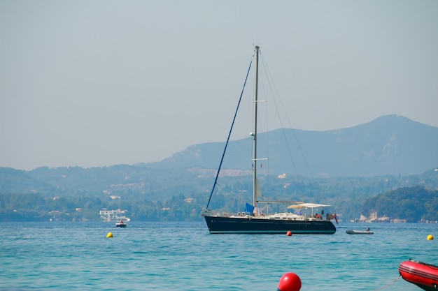 Seascape with sailboat the background of the blue sky and mountains Relax and travel conceptYachtingBoat sailing in blue Mediterranean sea in summer vacation Copy space