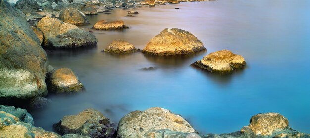 Seascape with stones in the water nature background Long exposure